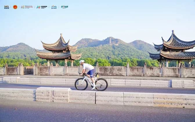 Cyclist on scenic route with Chinese architecture